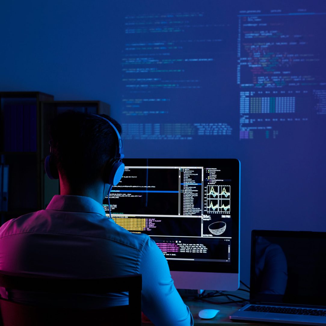 Working all night long Developer working on code late at night, view from the back